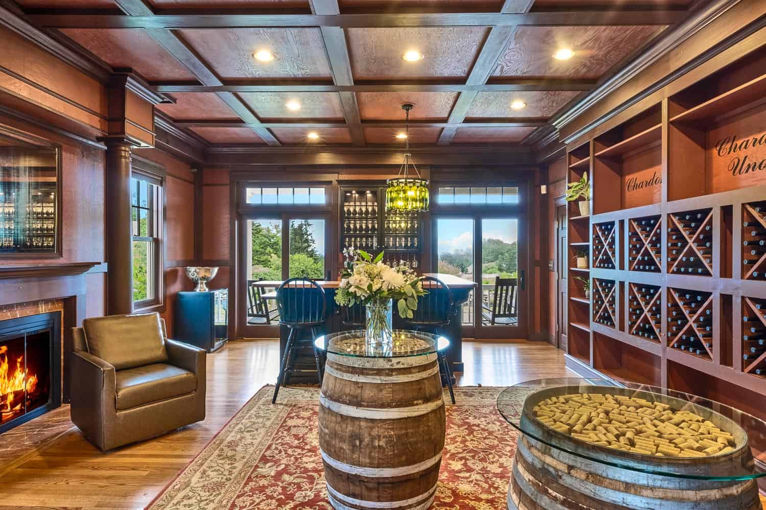 Elegant room featuring a central barrel table, wine rack, lit fireplace, and a sophisticated wooden design with ceiling panels.