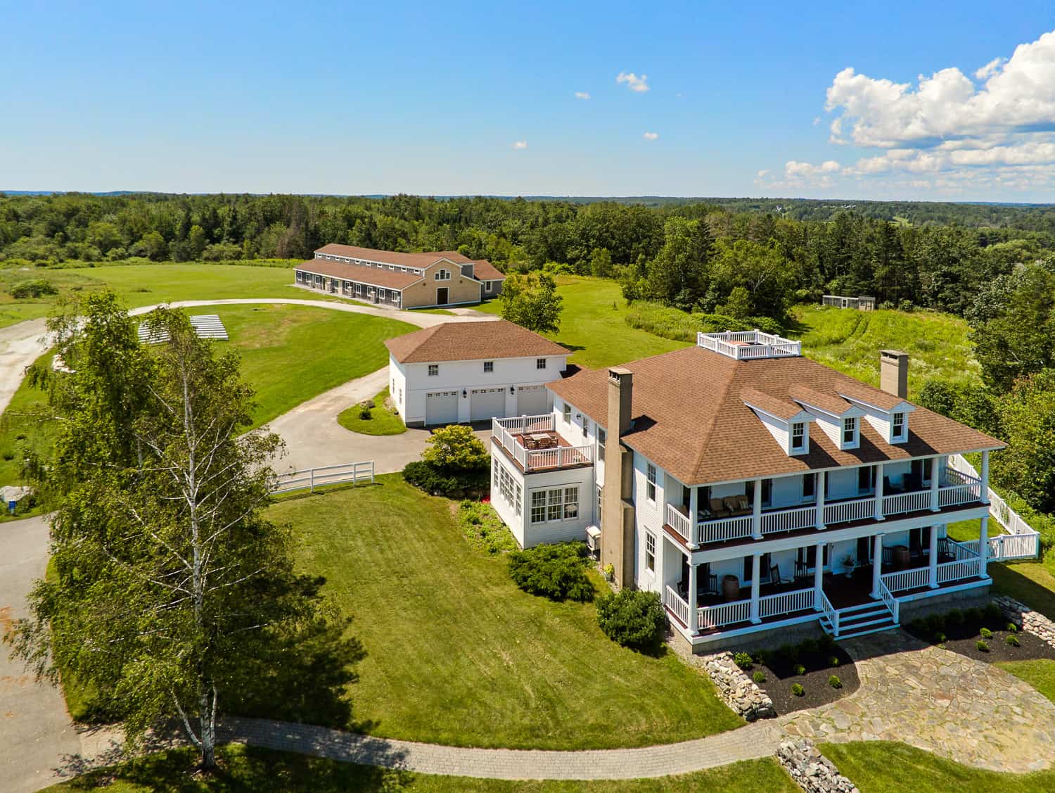 Aerial view of Ash Point Estate's main mansion with outbuildings on a sunny day.