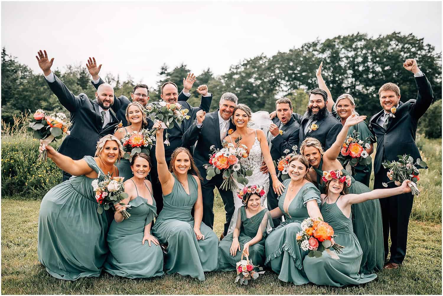 Bridal party cheering and raising their hands in the air.