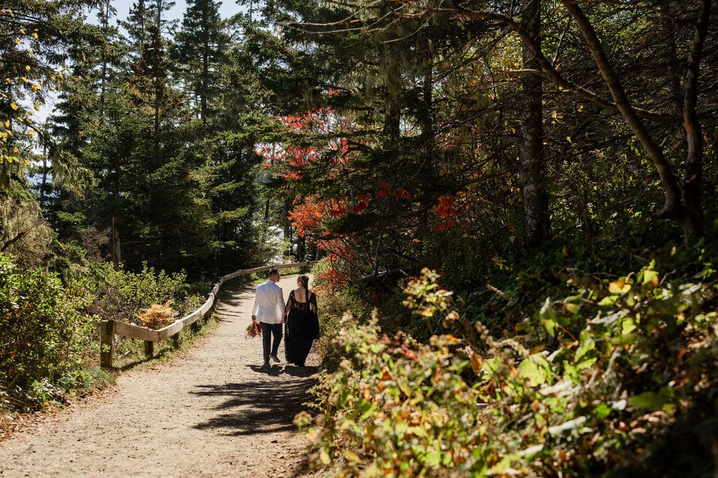 Best Maine Resorts For Weddings (Plus A Private Estate You Shouldn’t Miss) 5 Ash point estate maine resorts, newlyweds walk away down a wooded trail