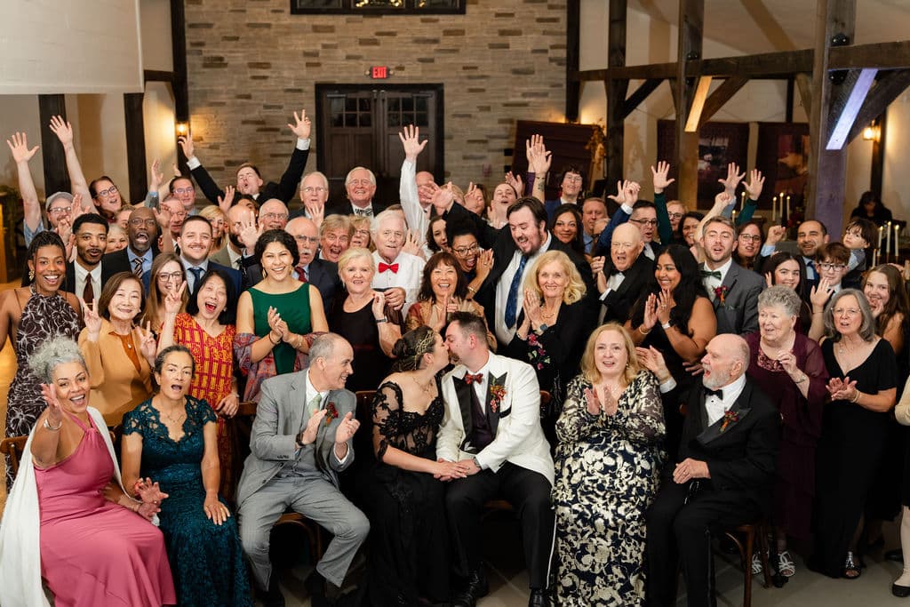 Ash point estate an alternative to family resorts in maine, wedding guests smile and wave to camera during wedding reception