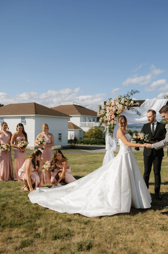 How To Choose The Perfect Wedding Reception Venue In Maine 1 Ash point estate wedding reception venues maine, bridesmaids in pink dresses fix bride's dress during wedding ceremony