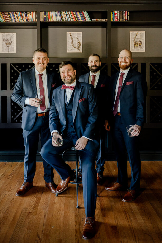 Groom and groomsmen toast in the bar at ash point estate