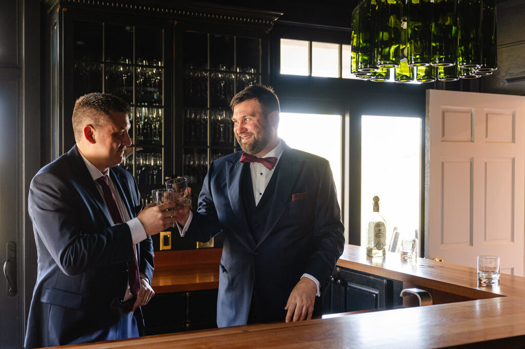 Groom and groomsmen toast in the bar at ash point estate