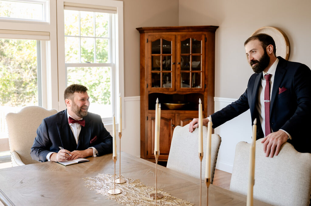 Groomsmen meet around table before wedding ceremony at ash point estate