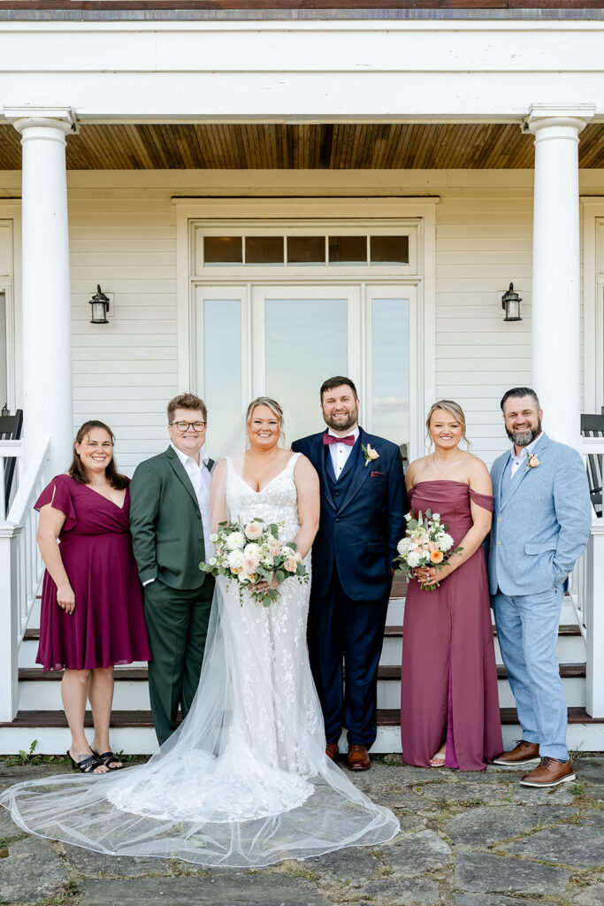 Bride, groom, and family stand in front of ash point estate