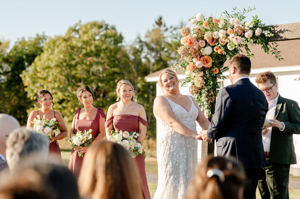 Couple at floral altar during wedding reception, ash point estate owls head, maine