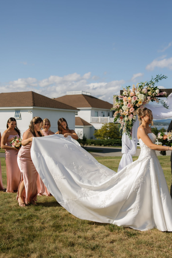 What Makes The Best Reception Venues In Maine Stand Out? 4 Ash point estate reception venues in maine, bride with bridesmaids in pink dresses holding up the train of the gown