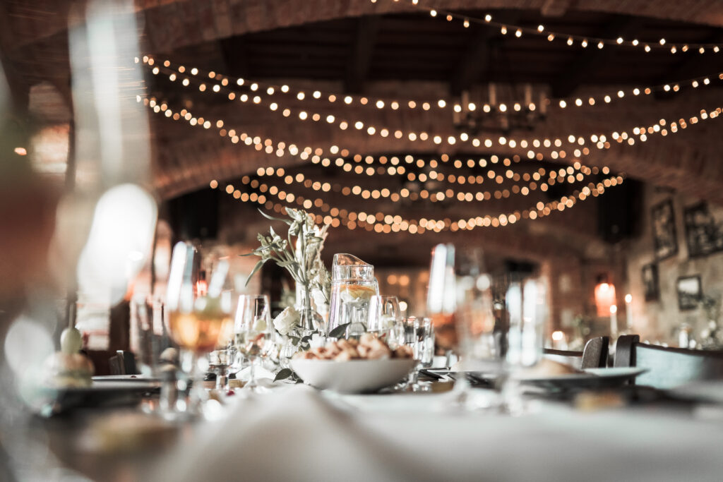 Beautiful wedding room with wedding table with food, flowers anddrinks, decorations,lights